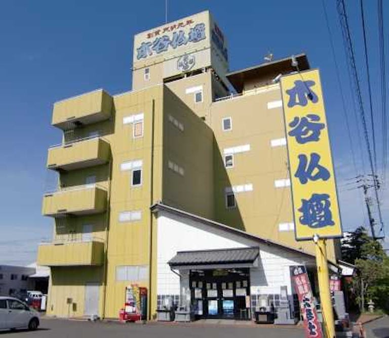 広い駐車場を完備した黄色い看板が目印の店舗外観