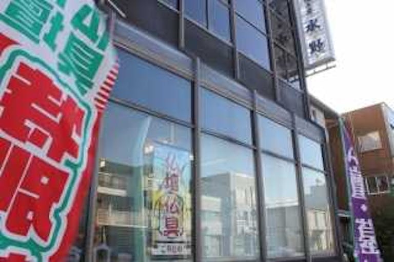 店舗前に立てられたのぼりとガラス張りの店舗正面から見える店内